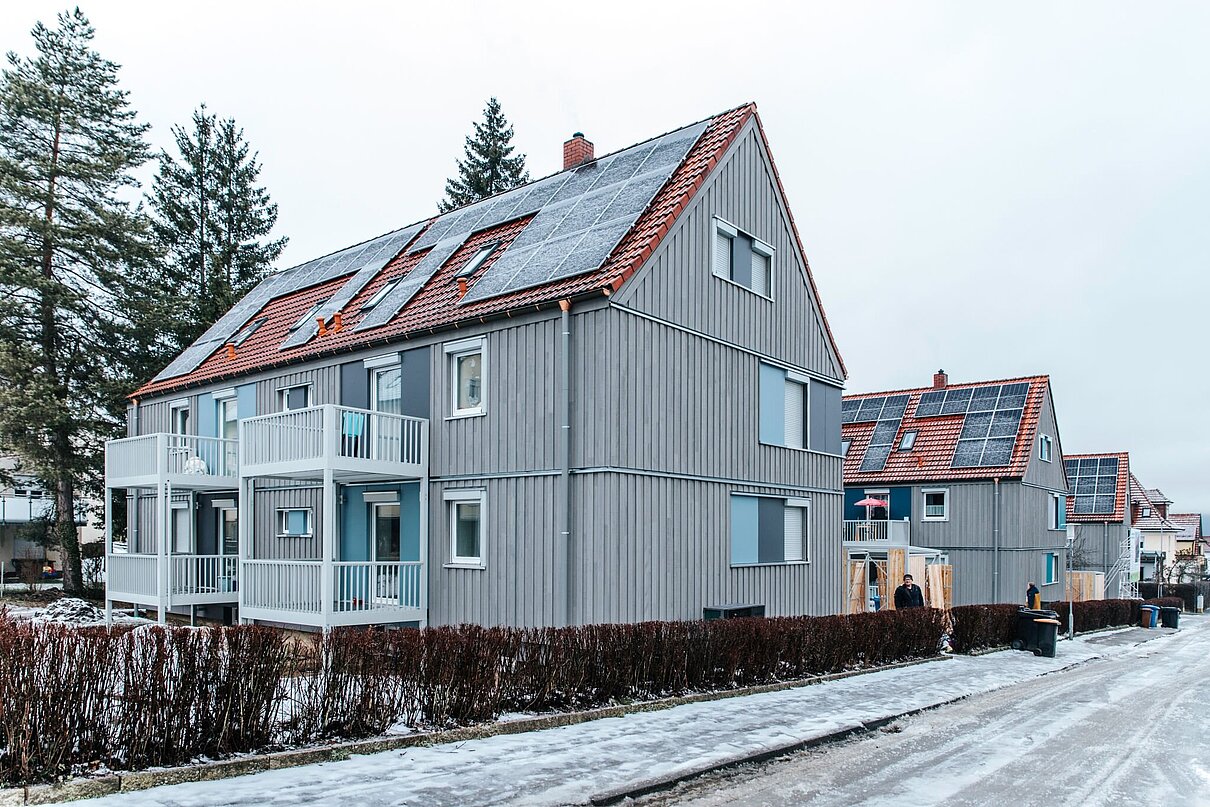 Mehrfamilienhaus zweigeschossig mit Schrägdach an einer Straße in einer Siedlung