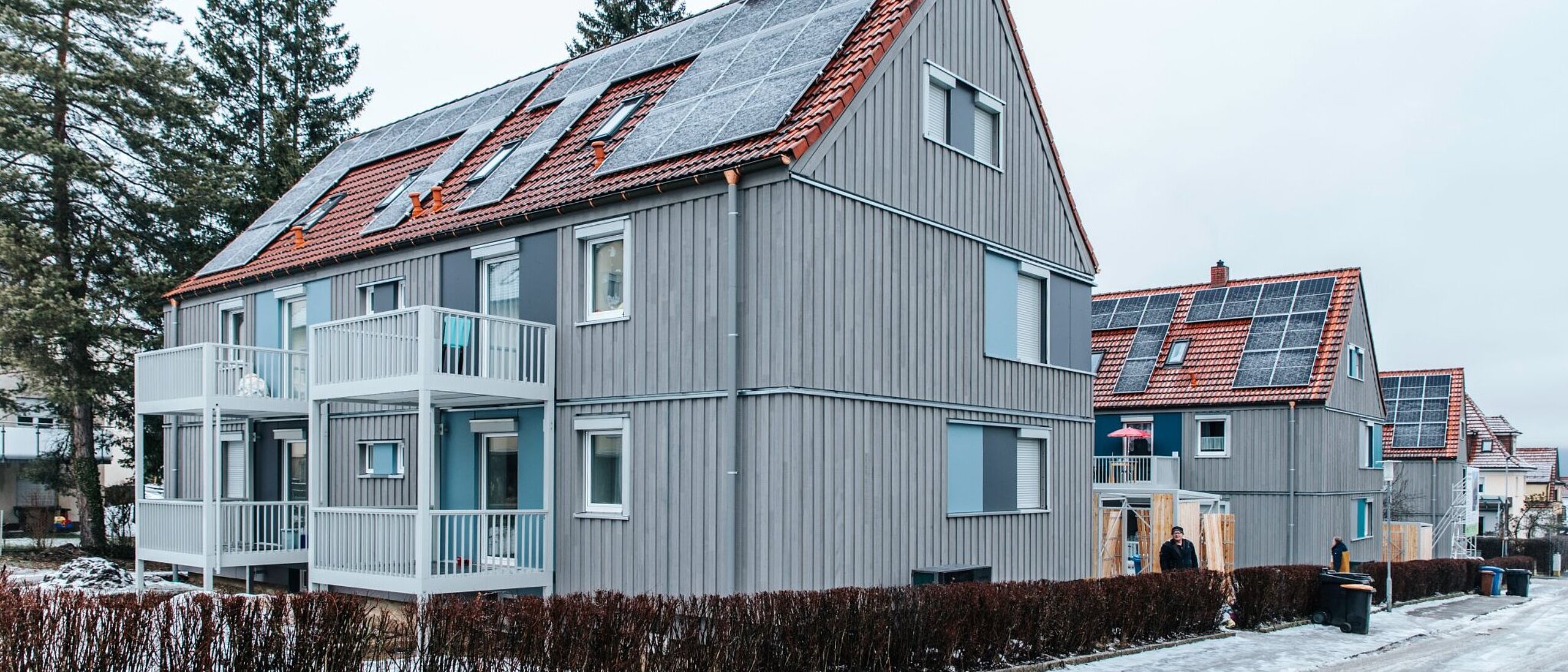 Mehrfamilienhaus zweigeschossig mit Schrägdach an einer Straße in einer Siedlung