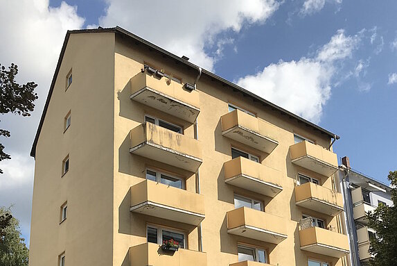 Mehrfamilienhaus fünfgeschossig mit Balkonen mit Putzfassade vor Sanierung