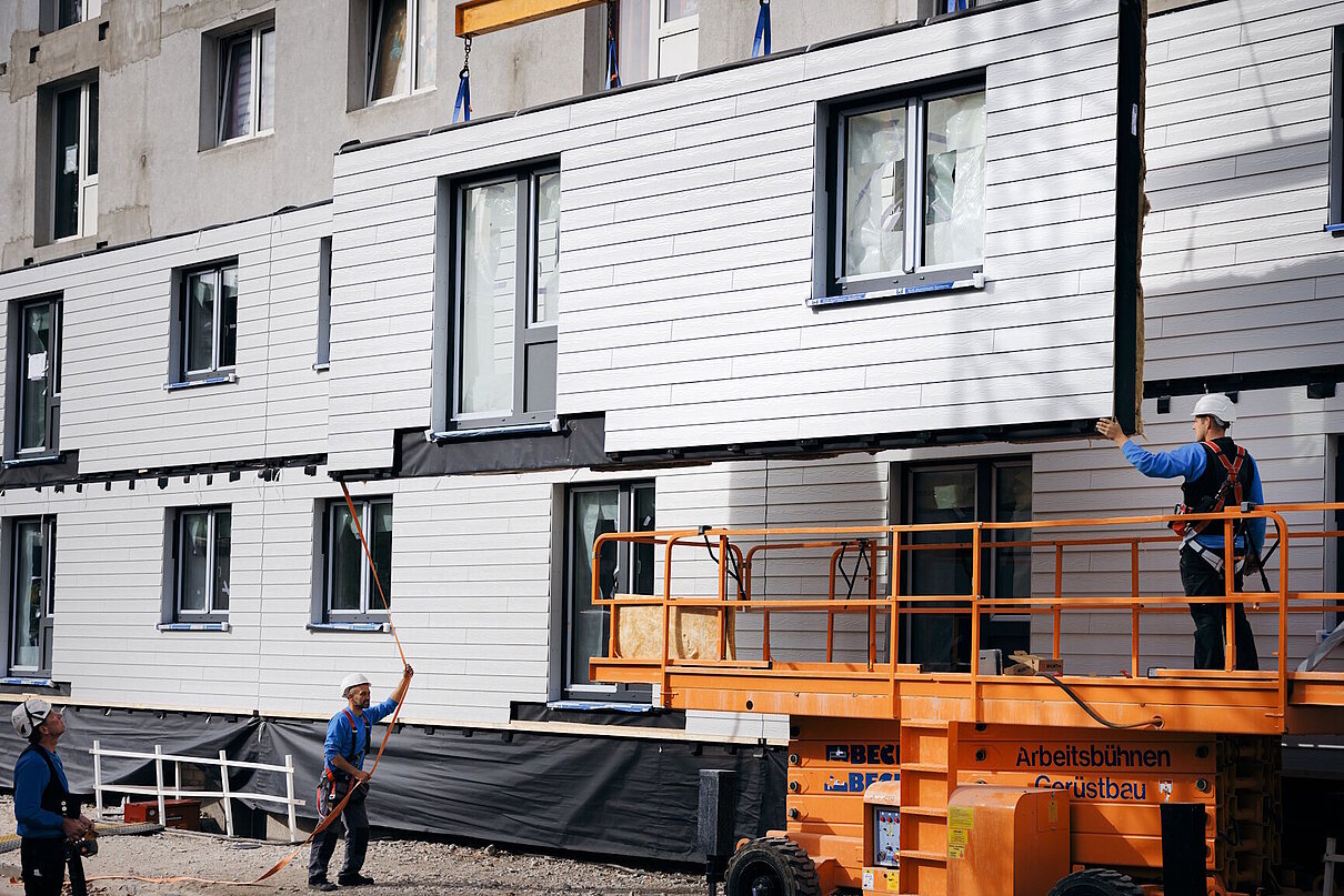 Schwebendes vorgefertigtes Fassadenelement vor Hausfassade