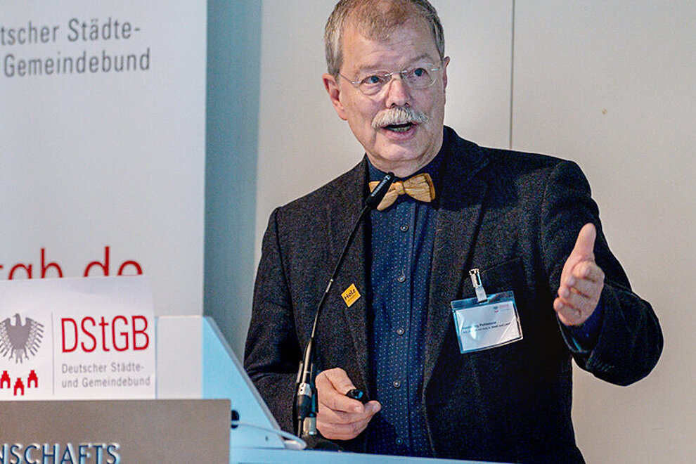 Person mit Jacket spricht auf einer Konferenz.