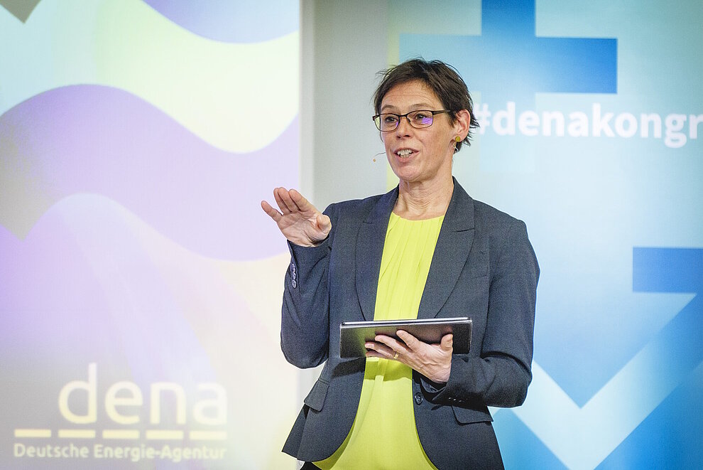 Person mit kurzen Haaren im Business-Outfit spricht, Hintergrundbild zum dena Kongress 