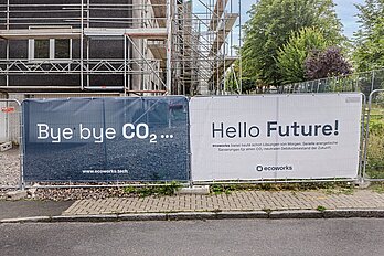 Banner an einem Bauzaun mit der Aufschrift: Bye bye CO2 ... Hello Future!